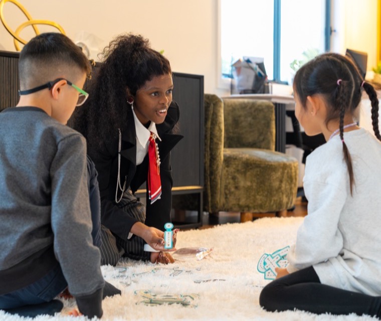 An occupational therapist sitting on the floor with two children during a session